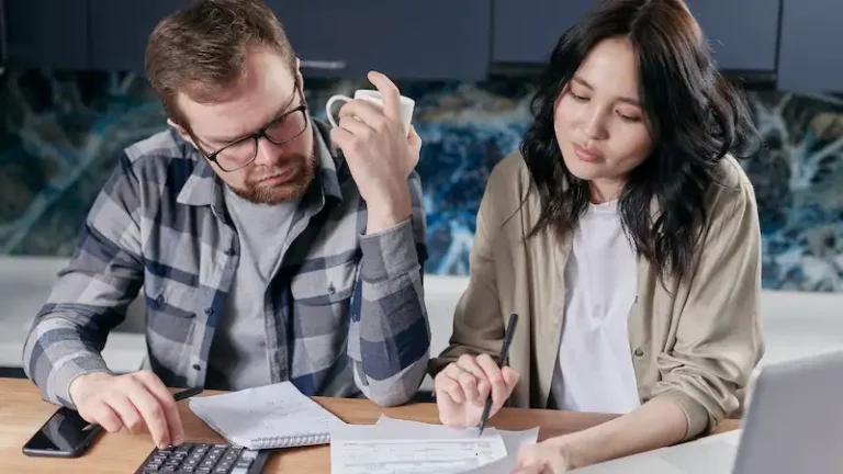Retired couple reviewing household bills and monthly expenses at a kitchen table